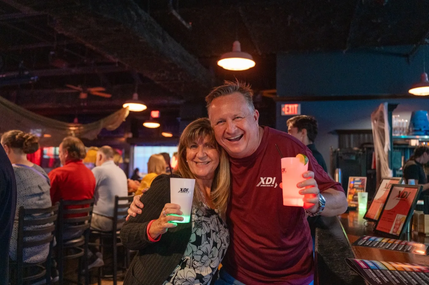 Kansas City corporate event photography - host and guest laughing together with light-up drinks