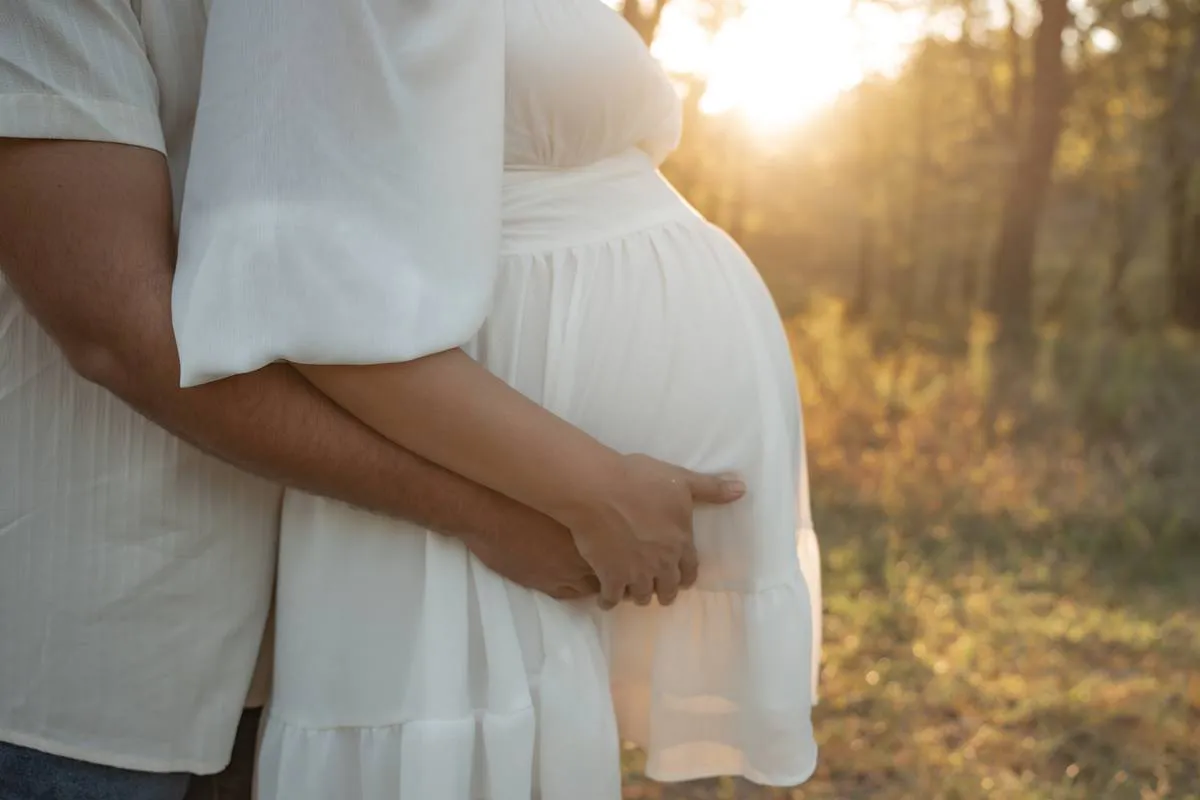 Kansas City maternity photographer - close-up of a couple's hands on a pregnant belly at golden hour